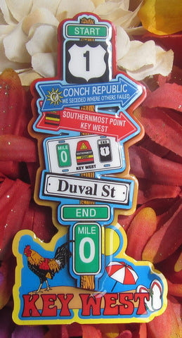 Magnet picture showing a 3D design of a multidirectional imaginary sign post: US 1 "START", "Conch Republic" and its famous say "We Seceded where others failed", Southernmost Point, the "3 points" (MIle 0, buoy and US 1 End), Duval Street, END Mile 0, with a rooster, umbrella, flip flops and "KEY WEST".