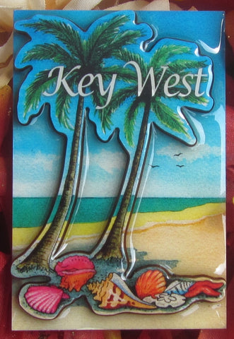 Magnet picture showing a 3D design of a beach: seaside view, palm trees and seashells on the sand, with "Key West".