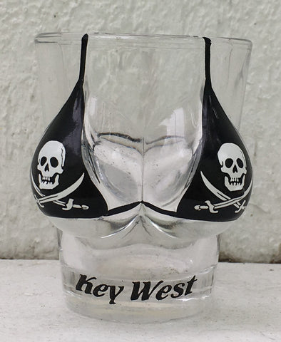 Shot glass shaped like a woman bust wearing a black bikini top with skulls and crossed swords. With "Key West" label.