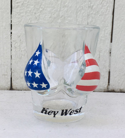 Shot glass shaped like a woman bust wearing an American flag bikini top. With "Key West" label.