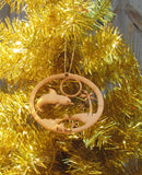 Wood ornament in the shape of a jumping dolphin, by the beach with palm tree and star shell. With "Key West".
