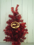 Wood ornament in the shape of a jumping dolphin, by the beach with palm tree and star shell. With "Key West".