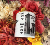 Front view mug showing "KEY WEST" written vertically between the Flagler's train and Sloppy Joe pictures.