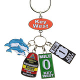 Key Chain with a "Key West" on an oval orange backgroup and 4 charms hanging underneath: a couple of dolphins, the Southernmost Point, Mile 0 sign and End US 1 sign.
