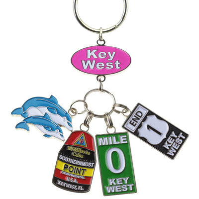 Key Chain with a "Key West" on an oval pink backgroup and 4 charms hanging underneath: a couple of dolphins, the Southernmost Point, Mile 0 sign and End US 1 sign.