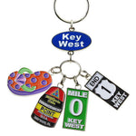 Key Chain with a "Key West" on an oval blue backgroup and 4 charms hanging underneath: a flip flop (orange with purple dots and green straps), the Southernmost Point, Mile 0 sign and End US 1 sign.
