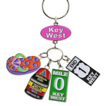 Key Chain with a "Key West" on an oval pink backgroup and 4 charms hanging underneath: a flip flop (orange with purple dots and green straps), the Southernmost Point, Mile 0 sign and End US 1 sign.
