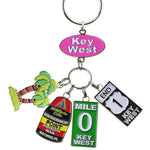 Key Chain with a "Key West" on an oval pink backgroup and 4 charms hanging underneath: a palm tree, the Southernmost Point, Mile 0 sign and End US 1 sign.