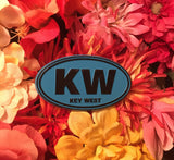 Magnet in oval shape with "KW" and "Key West". Blue and black.