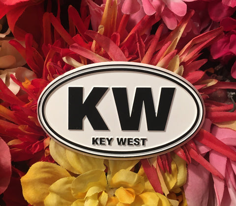 Magnet in oval shape with "KW" and "Key West". White and black.