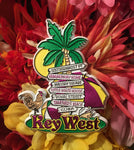 Magnet showing arrowed signs on a palm tree, directing to the Southernmost Point, Hemingway Home, Mallory Square, Little White House, Duval Street, Smathers Beach and to Cuba. With a rooster, a conch shell, an unbrella, a beach ball and "Key West".