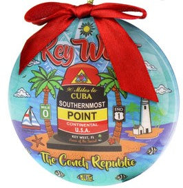Ornament picture showing the Southernmost Point with two palm trees on each side (one with the Mile 0 sign and the other with the US 1 End sign), a lighthouse, a sailboat, fishes, "Key West" (red letters) and "The Conch Republic" (yellow letters).