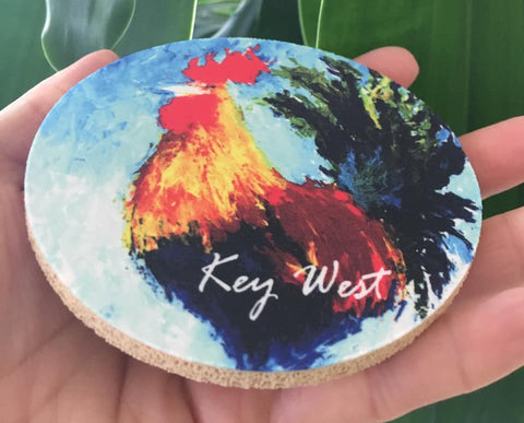 Rubber Coaster round showing a painting of a colorful rooster with "Key West" (white letters).
