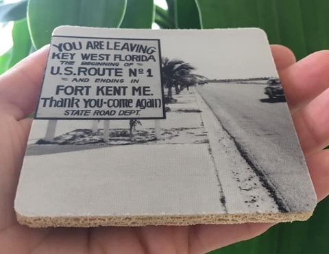 Rubber Coaster showing a mid 20th century picture of a Sate Road sign located on US1: "YOU ARE LEAVING KEY WEST FLORIDA, THE BEGINNING OF U.S. ROUTE No. 1 AND ENDING IN FORT KENT ME.", "Thank you - Come again - Sate Road Dept."