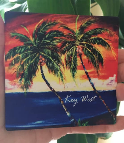 Sandstone Coaster picture showing a painting of palm trees in front of a sunset waterview.