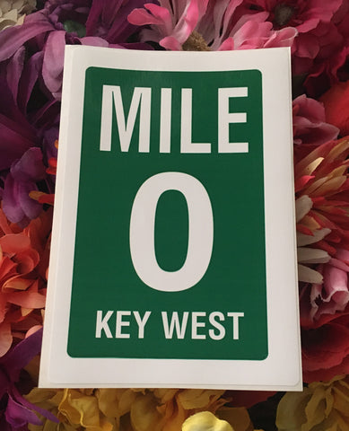 Large sticker showing the white and green "Mile 0 Key West" sign.