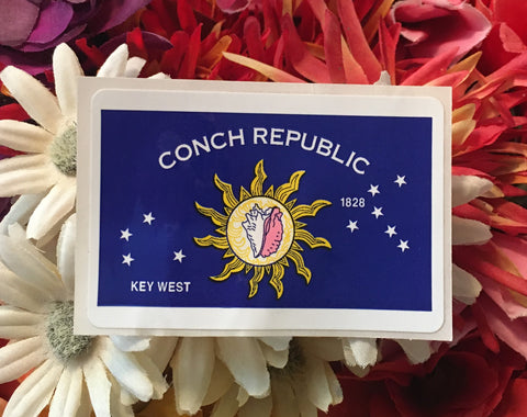Mini sticker showing the Conch Republic flag with the Conch Shell in the middle of the Sun, 4 stars on the left, 6 stars on the right, "CONCH REPUBLIC", "KEY WEST" and "1828".