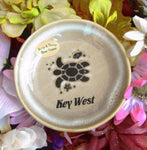 Natural color glaze dish showing a sea turtle, a tiny fish and a seashell, with "Key West".