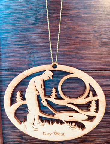 Wood ornament in the shape of a man playing golf. With "Key West".