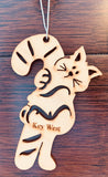 Wood ornament in the shape of a kitty holding on to a sugarcane as big as itself. With "Key West".