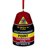 Ornament showing a figurine of the Southernmost Point (held by a red ribbon): at the top, a triangular design showing a conch shell and "The Conch Republic" (red background), then underneath "90 Miles to Cuba" and "SOUTHERNMOST" with a black background, then underneath "POINT" with a yellow background, then underneath "CONTINENTAL U.S.A." with a red background and finally at the bottom "KEY WEST, FL" with a black background.