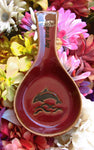 Red color spoon rest showing a jumping dolphin, with "Key West" on the handle.